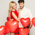 Un couple avec des ballons en forme de coeurs