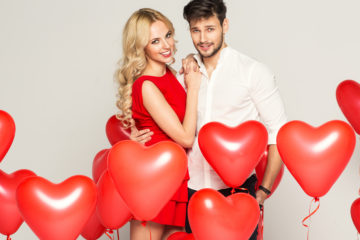 Un couple avec des ballons en forme de coeurs